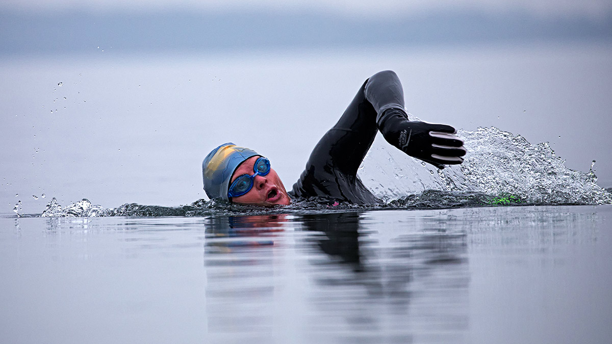 Triathlete In Goggles And Cap Swimming Straight In Open Water