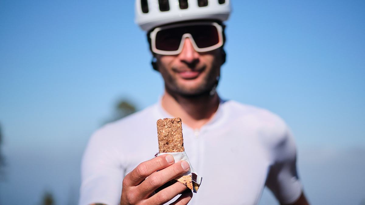 Recovery Like A Tour Rider Pro Tour De France Rider Holding Up A Nutrition Bar For Recovery