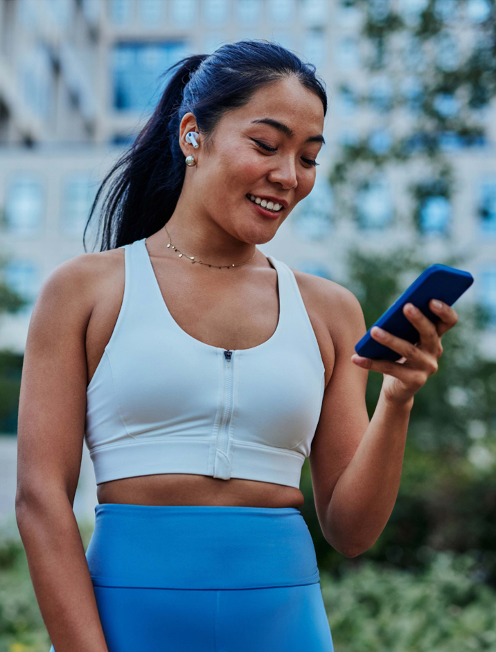 Athletic Woman Looking At Phone 716x942