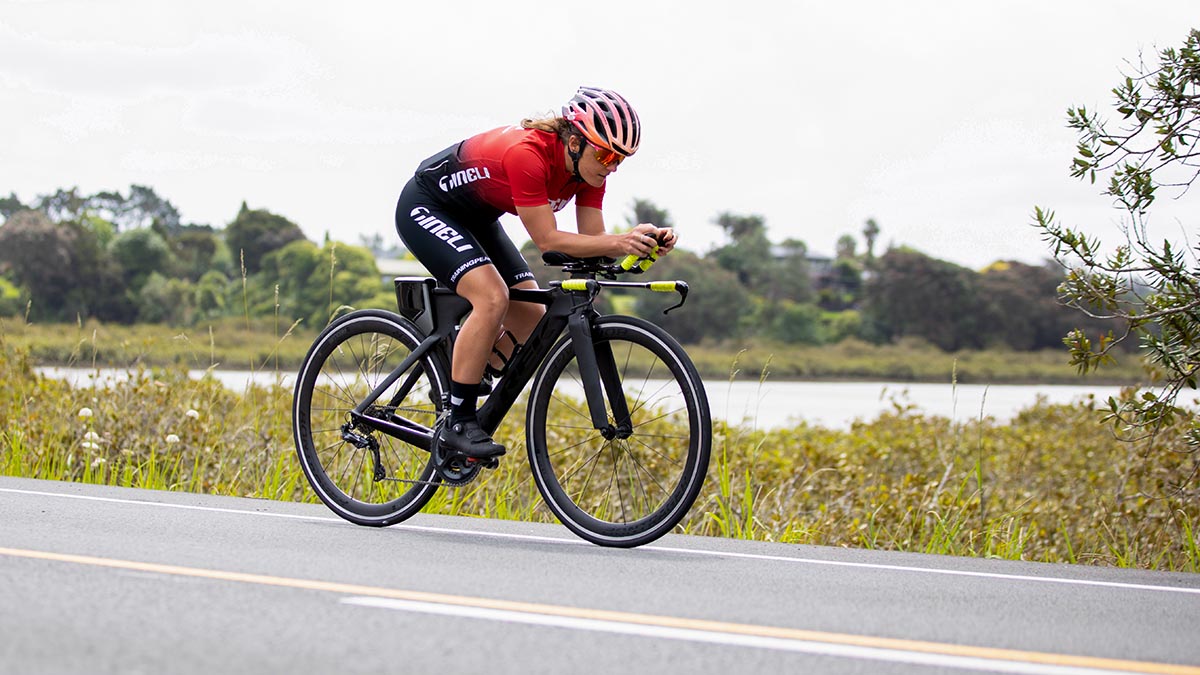 A Woman On A Time Trail Bike On The Aero Bars Riding On A Road